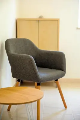 a gray chair sitting next to a wooden table at ALFELI-AP in Olhos de Água