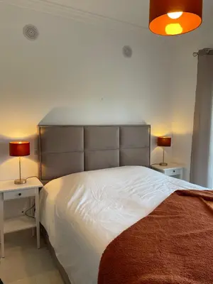 a bedroom with a large white bed with two night stands at ALFELI-AP in Olhos de Água