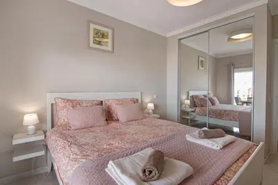 a bedroom with a large bed with a mirror at Vilamoura Apartment 3 bedroom in Vilamoura