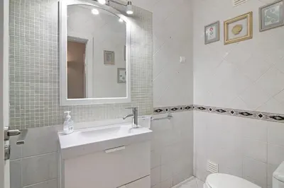 a bathroom with a sink and a toilet and a mirror at Vilamoura Apartment 3 bedroom in Vilamoura