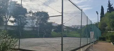 a tennis court with a chain link fence at Sweet Garden by SpotOn Apartments in Albufeira