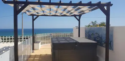 a pergola on a balcony with the ocean in the background at Villa Albuar in Patroves