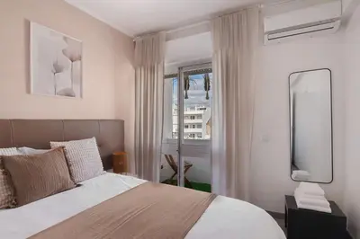 a bedroom with a bed and a mirror and a window at Casa Maria in Faro