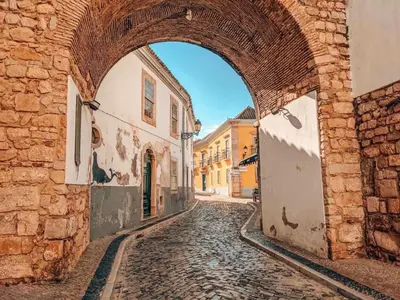 an alley in an old town with an archway at Casa Maria in Faro