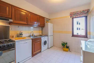 a kitchen with a white refrigerator and a dishwasher at Albufeira Salgados Beach 2 by Homing in Albufeira