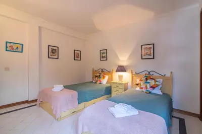 a bedroom with two beds and a lamp on a table at Albufeira Salgados Beach 2 by Homing in Albufeira