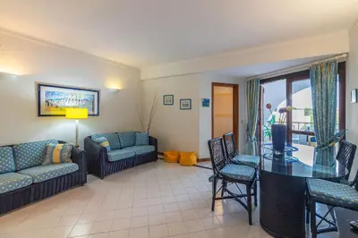 a living room with a couch and a table and chairs at Albufeira Salgados Beach 2 by Homing in Albufeira