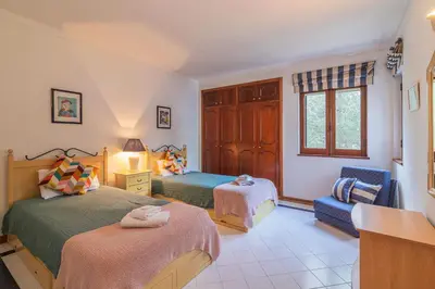 a bedroom with two beds and a chair and a window at Albufeira Salgados Beach 2 by Homing in Albufeira