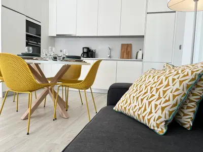 a living room with a table and chairs and a kitchen at Terraços Quarteira 2D3 in Quarteira