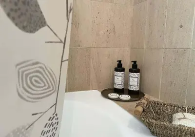 a bathroom with a bath tub and two bottles of soap at Title e Title - Oura Apartament Albufeira in Albufeira
