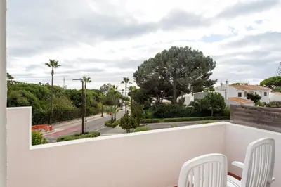 a balcony with white chairs and a view of a street at Townhouse Seraphina in Vale do Lobo