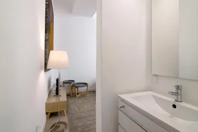 a kitchen with a sink and a counter with stools at Casa Vermelha ii in Faro