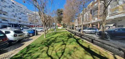 a street with cars parked on the side of the road at Apartamento Dionisio in Albufeira
