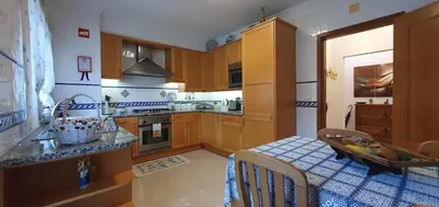 a kitchen with wooden cabinets and a blue and white at Apartamento Dionisio in Albufeira
