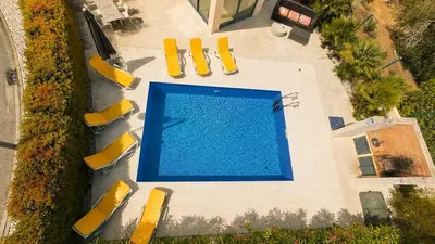 a kitchen with a washing machine and a table with chairs at LINDA Oura Beach 4BR Villa 10 New for rent! in Albufeira