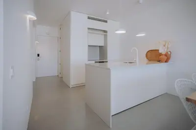 a white kitchen with a white island in a room at Casa Balaia 70 in Albufeira