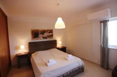 a bedroom with a bed and a painting on the wall at Lago Azul Apartment II in Quarteira