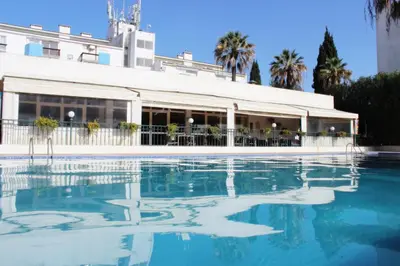 a swimming pool in front of a building at Lago Azul Apartment II in Quarteira