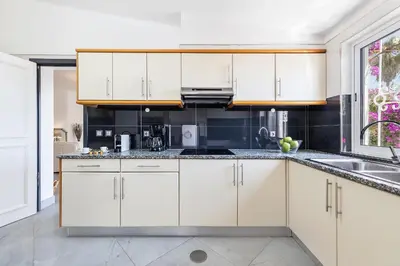 a kitchen with white cabinets and a sink at Villa Eva by OCvillas in Albufeira