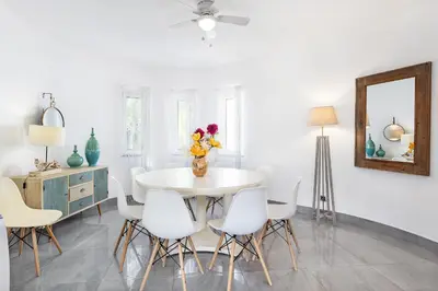 a dining room with a white table and white chairs at Villa Eva by OCvillas in Albufeira