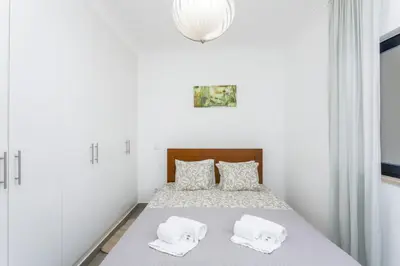a white bedroom with a bed with two pillows at Miral 3 - Sea front by HD PROPERTIES in Quarteira