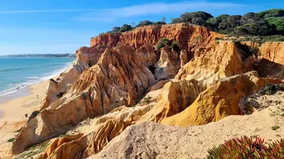 a view of a sandy beach and cliffs next to the ocean at Albufeira Balaia Mar e Sol in Albufeira