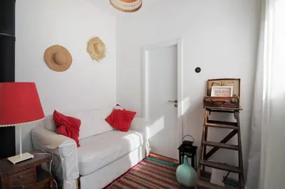 a living room with a white couch and red pillows at Casa Loulé in Loulé