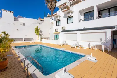 a villa with a swimming pool and a house at Old Town Beach Apartments in Albufeira