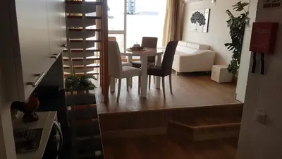 a living room with a table and chairs and a staircase at Sun way in Albufeira