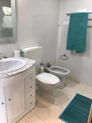 a bathroom with a tub and a green towel at Vilamoura holidays house in Vilamoura