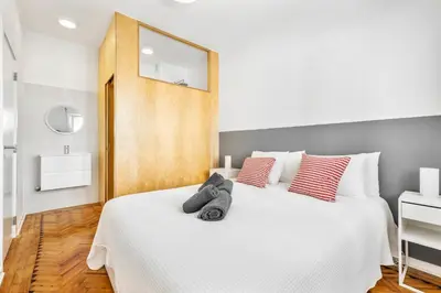 a bedroom with a white bed with red and gray pillows at RG Sunny Ap in Faro