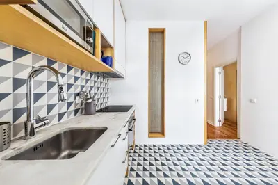a kitchen with a sink and a tile floor at RG Sunny Ap in Faro