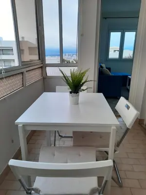 a white table with a plant on it in a room with windows at Casa Oceano 1Bedroom apartment W/sea view in Quarteira