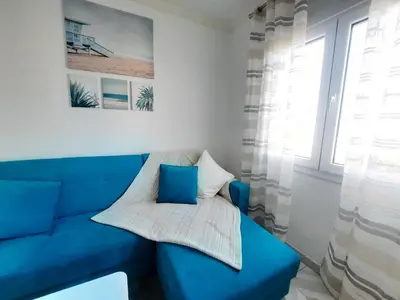 a blue couch in a room with a window at Casa Oceano 1Bedroom apartment W/sea view in Quarteira