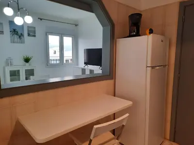 a small kitchen with a table and a refrigerator at Casa Oceano 1Bedroom apartment W/sea view in Quarteira
