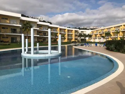 a swimming pool in front of a large apartment building at MARINA BLEU Magnifique Appartement Standing vue Piscine in Albufeira
