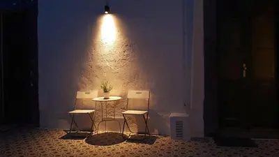 a room with three chairs and a table and a light at A Casa do Tenente in Faro