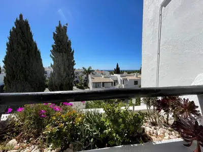 a view from the balcony of a house with flowers at Vue mer et piscine à 5 min à pied de Praia Sao Rafael Albufeira in Albufeira