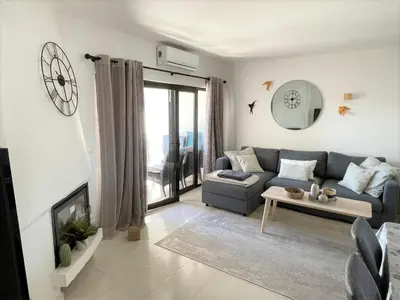 a living room with a couch and a table at Vue mer et piscine à 5 min à pied de Praia Sao Rafael Albufeira in Albufeira