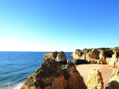 a beach with some rocks and the ocean at Vue mer et piscine à 5 min à pied de Praia Sao Rafael Albufeira in Albufeira