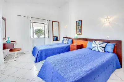 a bedroom with two blue beds and a window at Villa Brigida in Patroves