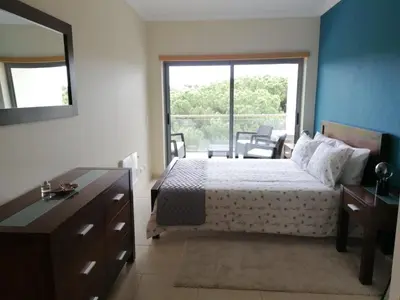a bedroom with a bed and a large window at Casa Jacqueline in Albufeira