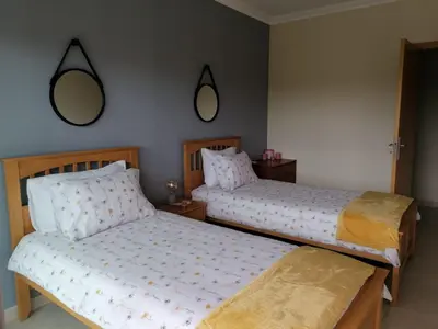 two beds in a bedroom with two mirrors on the wall at Casa Jacqueline in Albufeira