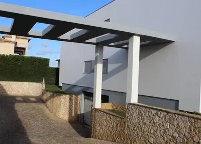 a white building with a black roof and a stone wall at Casa Jaffa in Albufeira