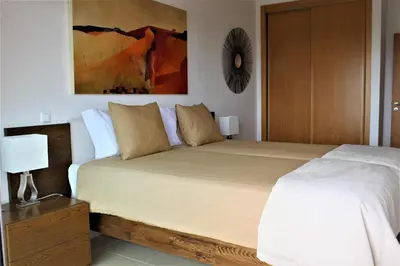 a bedroom with a bed and a painting on the wall at Casa Jaffa in Albufeira