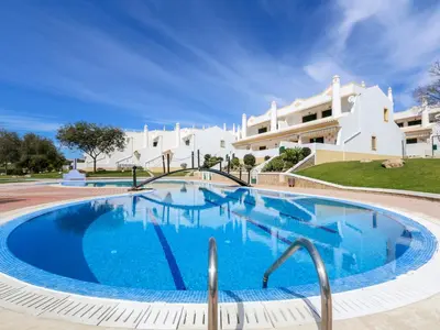 a large swimming pool in front of a building at Cozy Townhouse Vila Rafaella near São Rafael Beach Albufeira in Albufeira