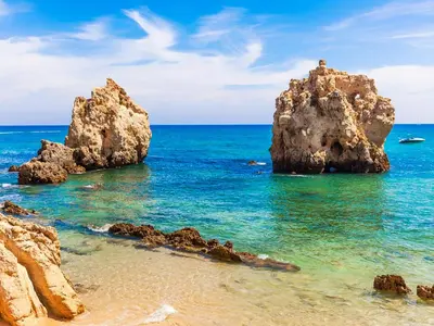 a group of rocks in the water on a beach at Cozy Townhouse Vila Rafaella near São Rafael Beach Albufeira in Albufeira