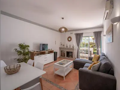 a living room with a couch and a table at Cozy Townhouse Vila Rafaella near São Rafael Beach Albufeira in Albufeira