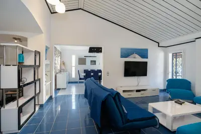 a living room with blue furniture and a tv at Villa Vitry by Intiholidays in Albufeira