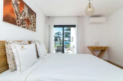 a bedroom with a white bed and a window at Villa Videira By Dalma Portuguesa - By Dalma Portuguesa in Albufeira
